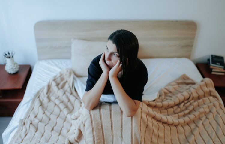 Sad Woman Sitting Alone on Bed, Coping with Nighttime Depression